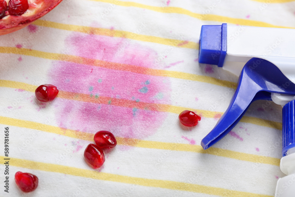 Laundry detergent with pomegranate on stained clothes, closeup