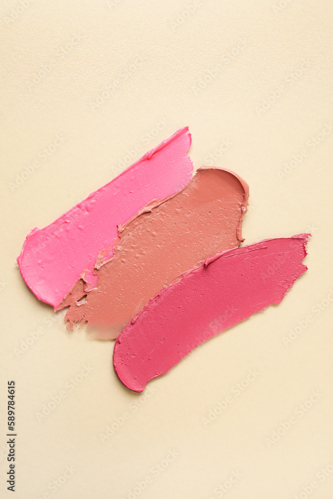 Different lipstick strokes on beige background