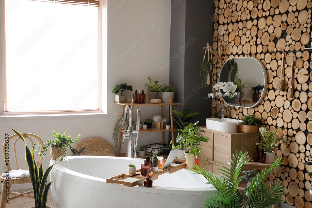 Interior of bathroom with green houseplants, sink and mirror