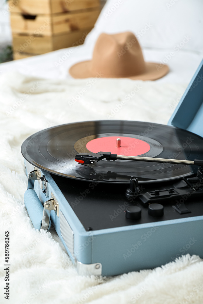 Record player with vinyl disk on bed in room, closeup