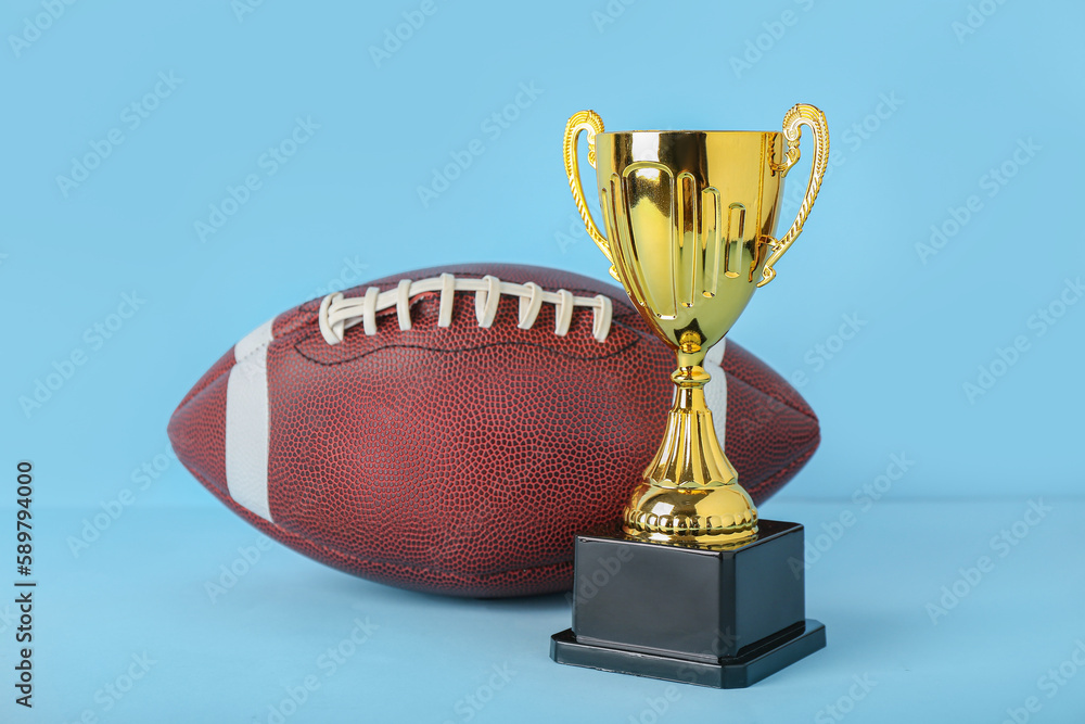 Gold cup with rugby ball on blue background