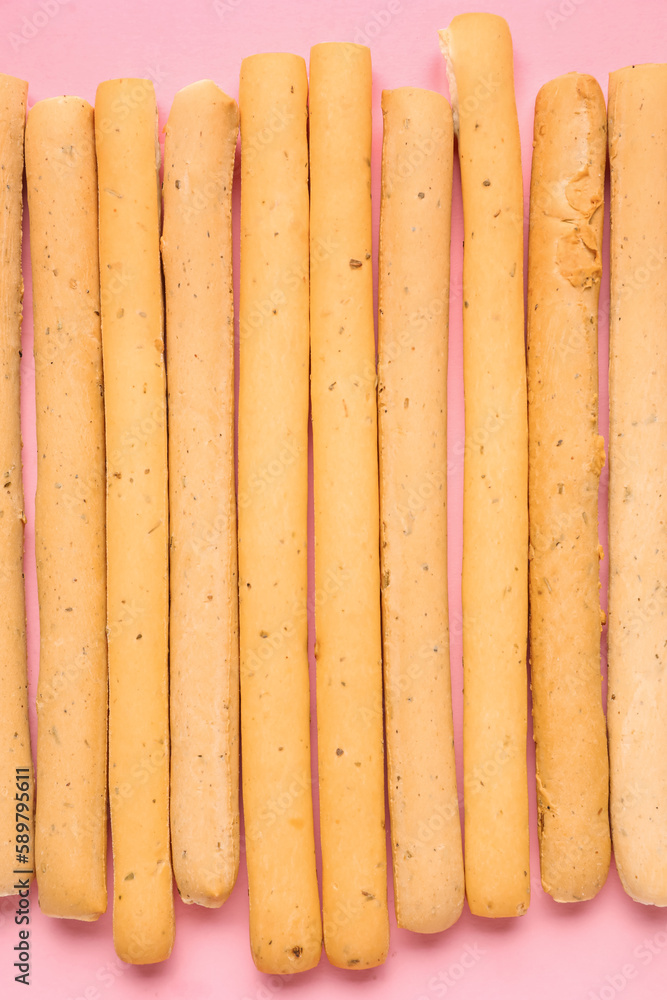 Tasty Italian Grissini on pink background