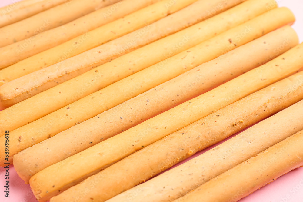 Tasty Italian Grissini on pink background, closeup