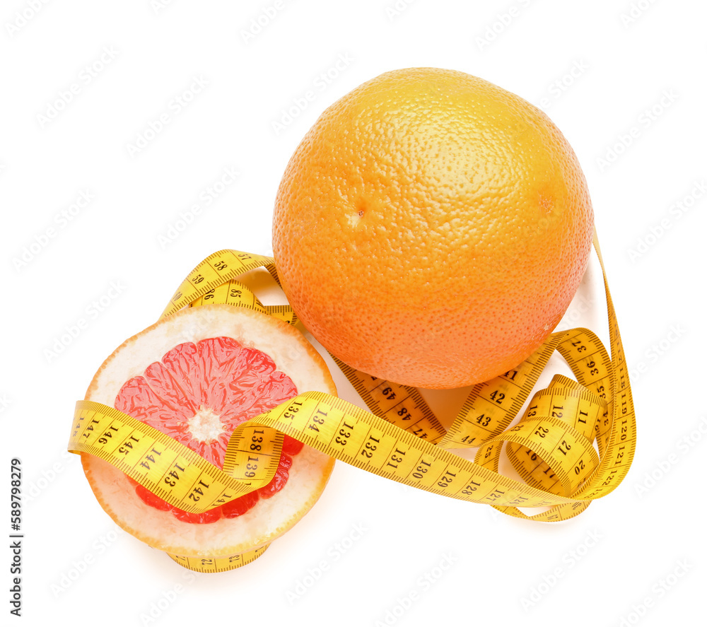 Cut and whole grapefruit with yellow measuring tape on white background. Diet concept