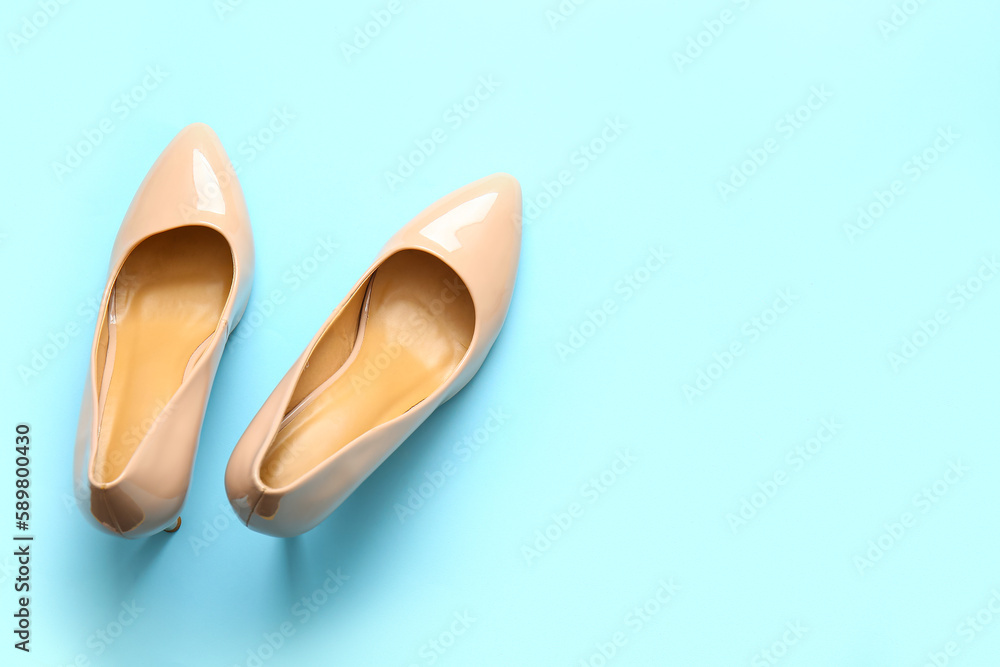 Pair of stylish high heeled shoes on light blue background