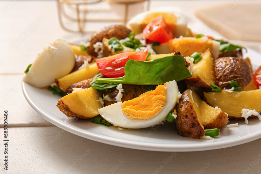 Plate of tasty potato salad with eggs and tomatoes on light wooden background, closeup