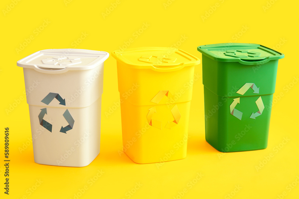 Containers for garbage on yellow background. Recycling concept