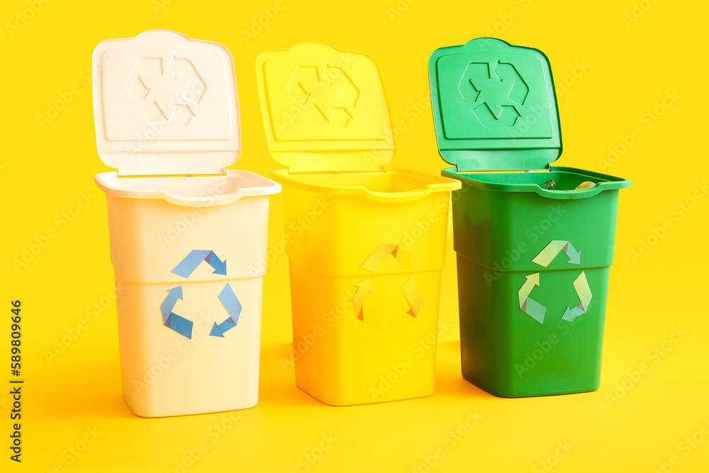 Containers for garbage on yellow background. Recycling concept