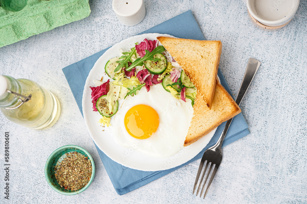 Plate with tasty fried egg, toast and salad on light table