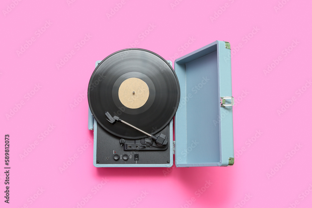 Record player with vinyl disk on pink background