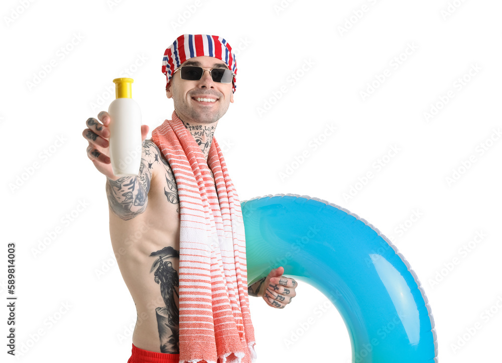 Tattooed man with sunscreen cream and swimming ring on white background