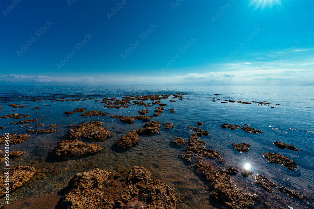 Rocky lake shore in the sunlight, Issyk-Kul, Kyrgyzstan