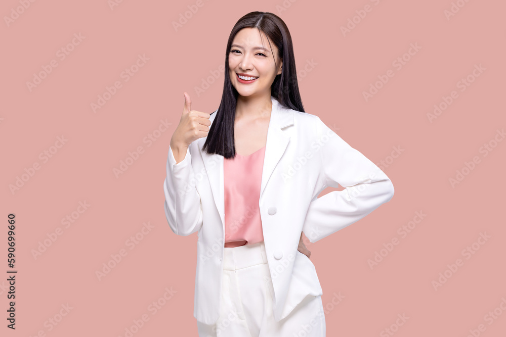 Portrait happy Asian woman shows thumb up and looking at the camera on pink background.