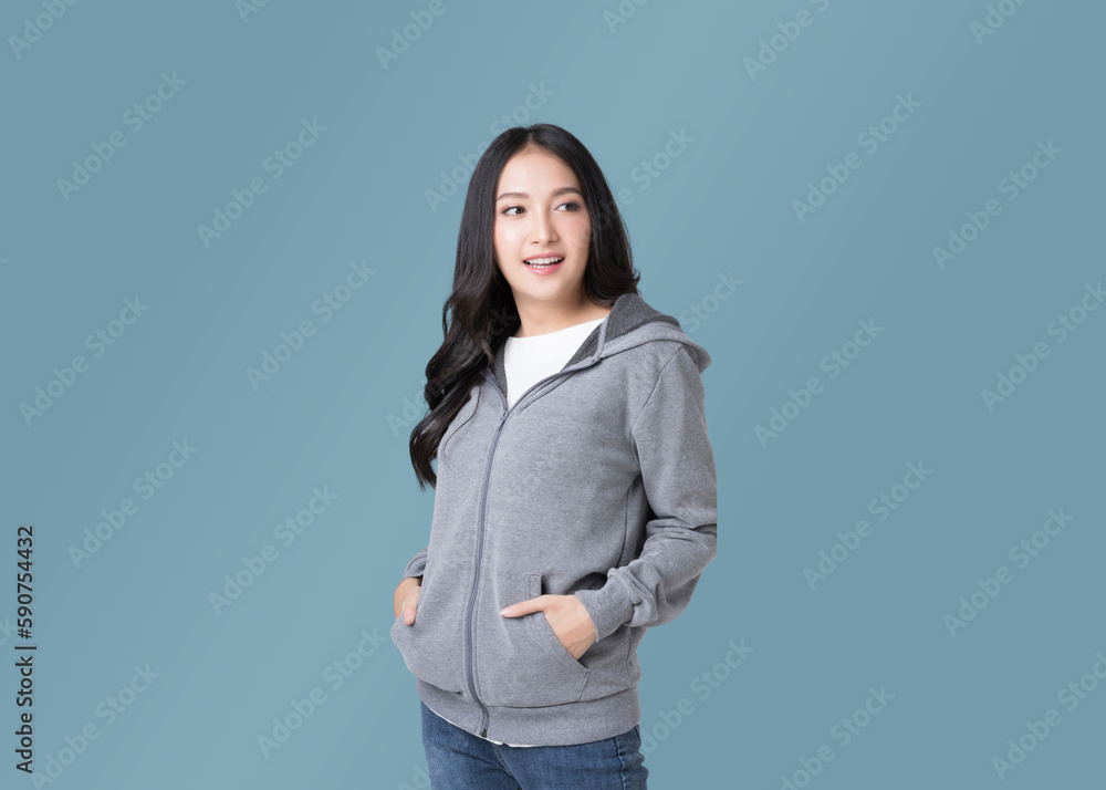 Portrait beautiful Asian woman in hoodie sweatshirt and blue jeans isolated over cyan background