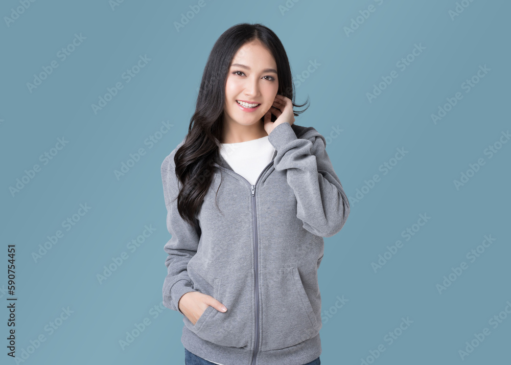 Portrait beautiful Asian woman in hoodie sweatshirt and blue jeans isolated over cyan background