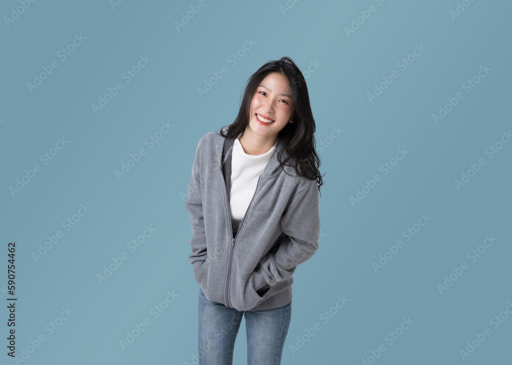 Portrait beautiful Asian woman in hoodie sweatshirt and blue jeans isolated over cyan background