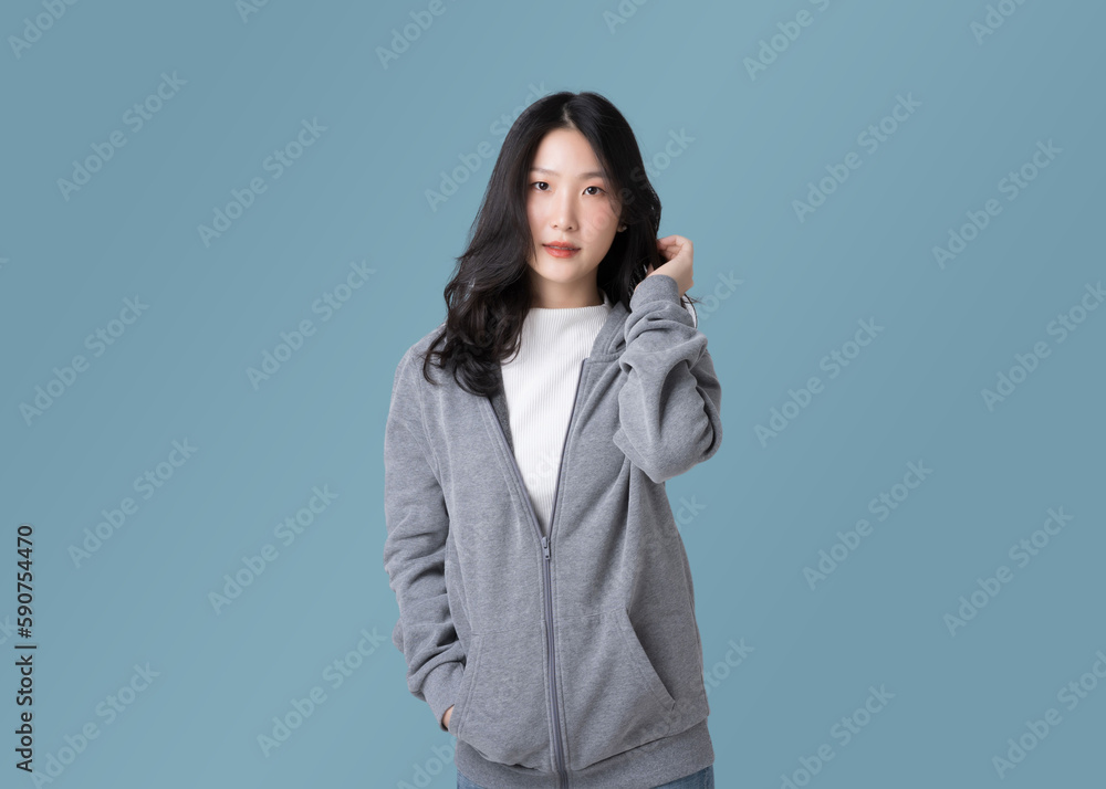 Portrait beautiful Asian woman in hoodie sweatshirt and blue jeans isolated over cyan background