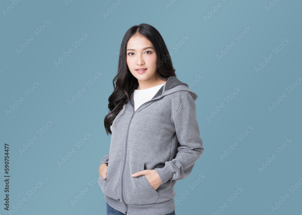 Portrait beautiful Asian woman in hoodie sweatshirt and blue jeans isolated over cyan background