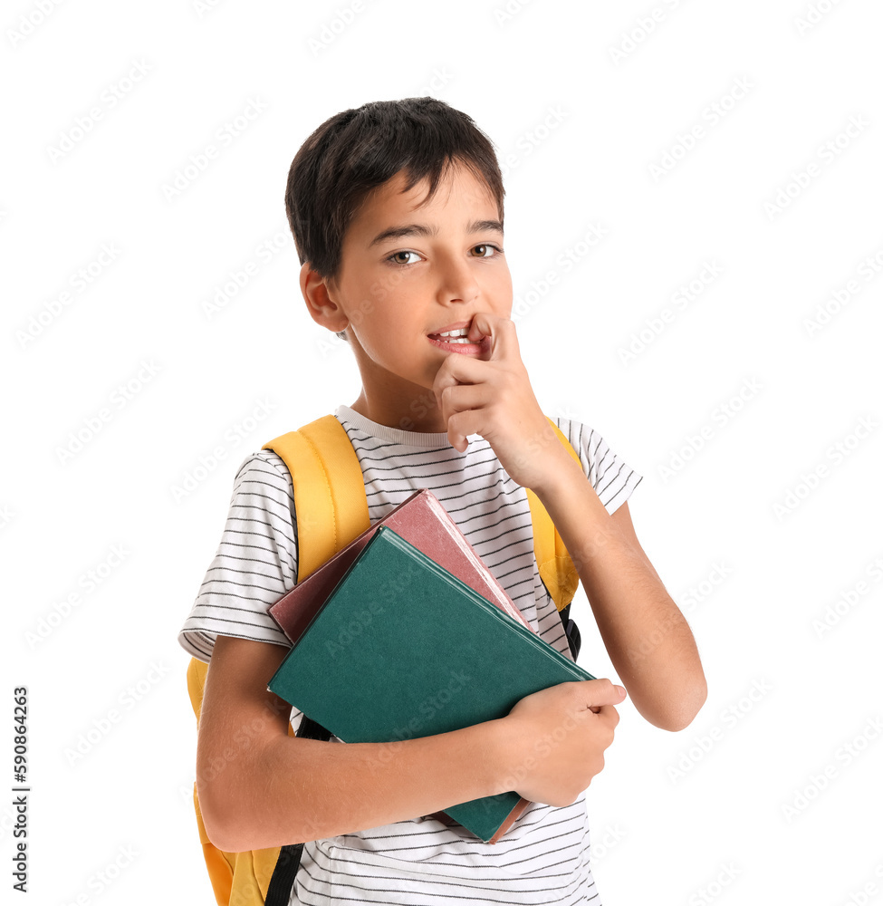 Little schoolboy with books biting nails on white background