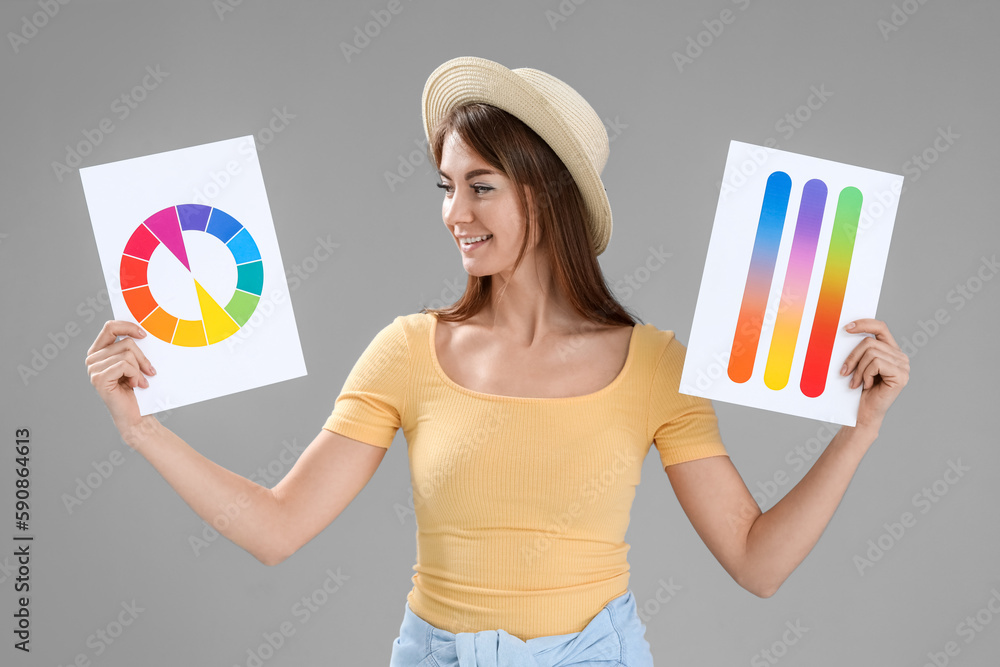 Beautiful woman with paint color palettes on grey background