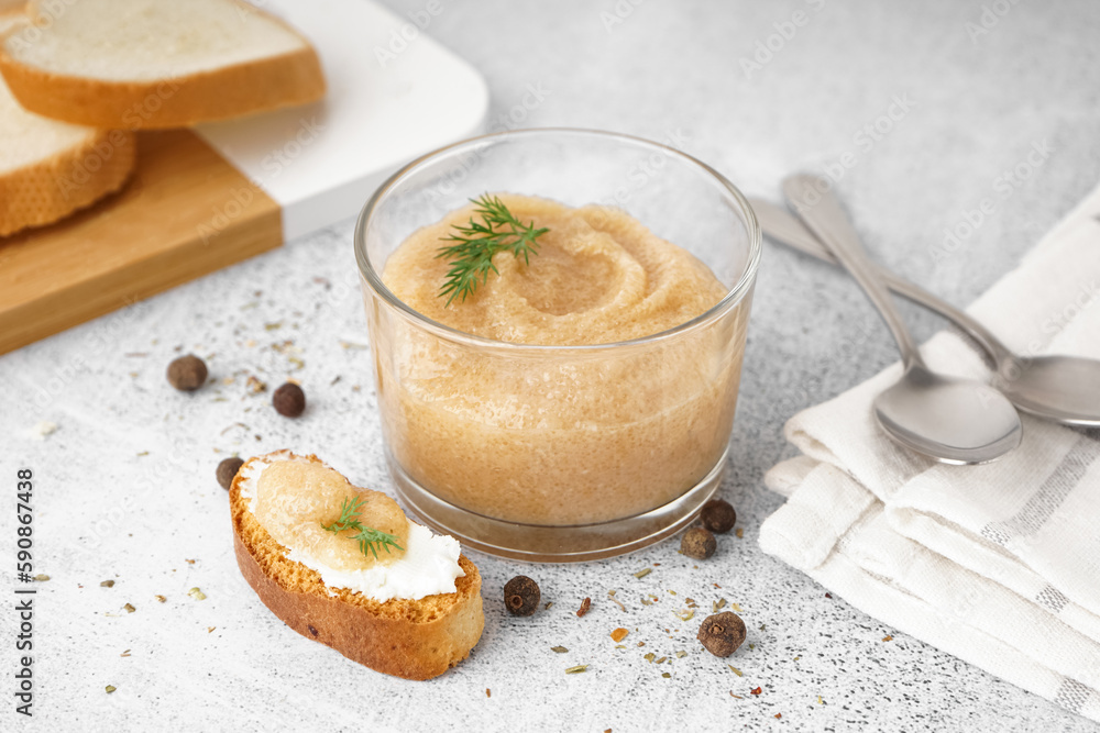 Glass with delicious caviar of capelin and crouton on grey background