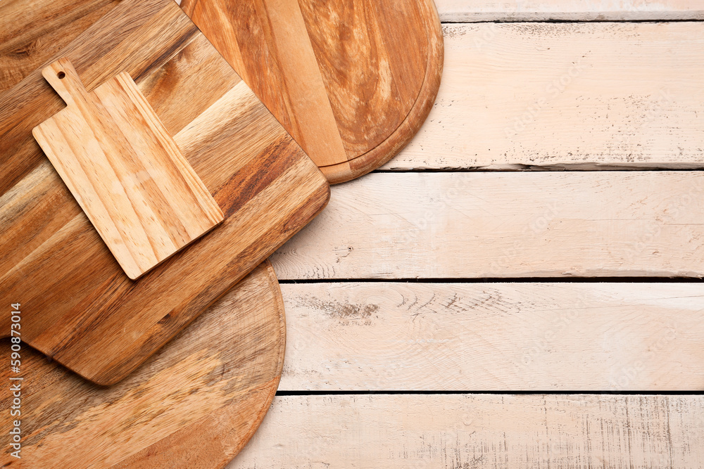 Set of different cutting boards on light wooden background