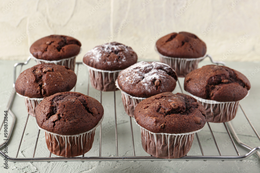 Grid with tasty chocolate cupcakes on table