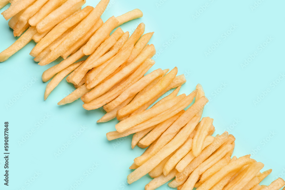 Tasty french fries on light blue background