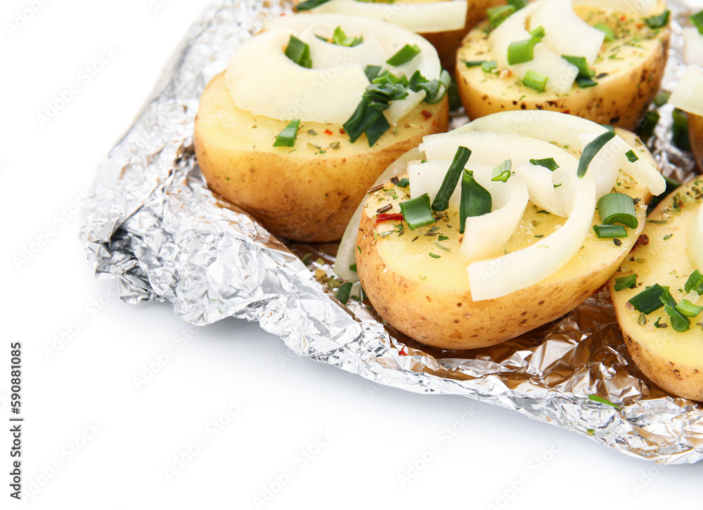 Aluminium foil with raw potato and onion on white background, closeup