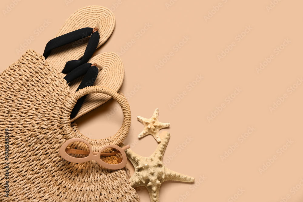 Bag with flip-flops, sunglasses and starfishes on beige background