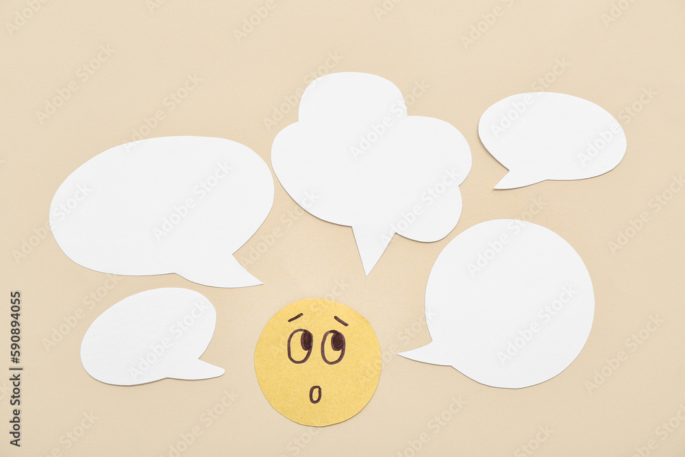 Paper face with speech bubbles on beige background. Dialogue concept