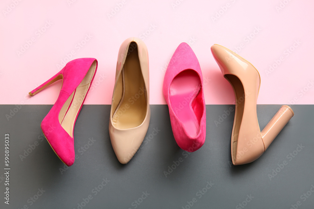 Fashionable high heeled shoes on color background