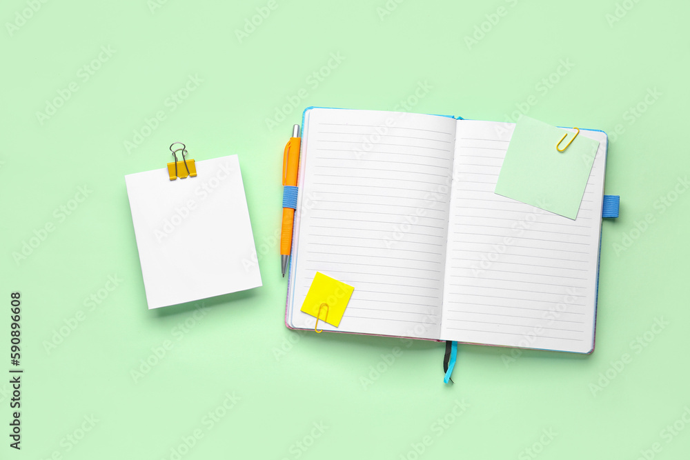 Sticky notes and notepad on green background