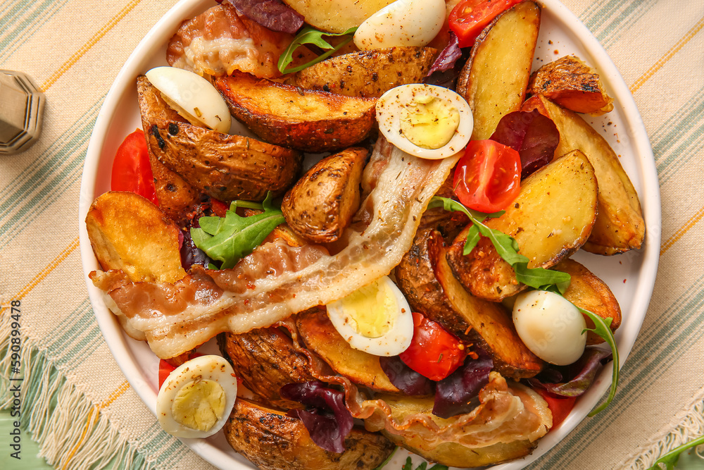 Plate of tasty potato salad with eggs, tomatoes and bacon on table, top view