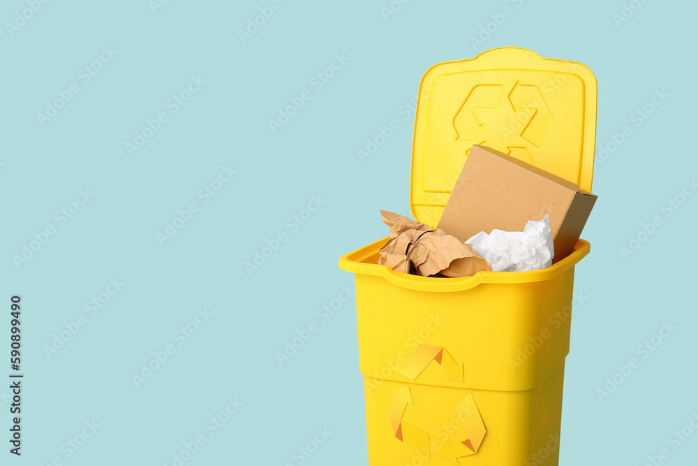 Container for garbage with paper on light blue background. Recycling concept