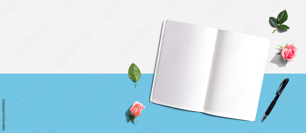 Open notebook or diary with a pen from above with rose buds- flat lay