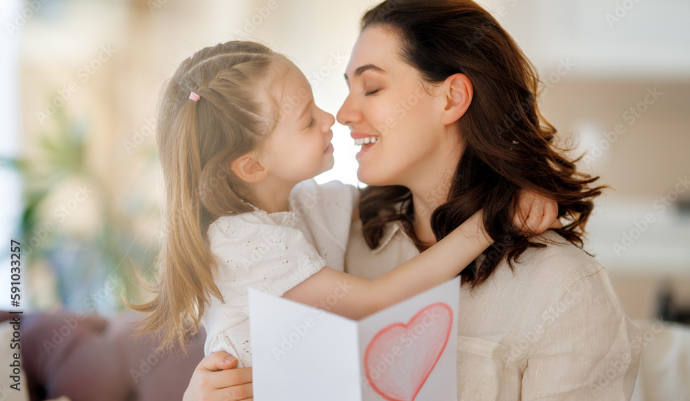 Daughter giving mother bouquet of flowers.