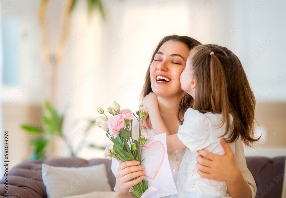 Daughter giving mother bouquet of flowers.