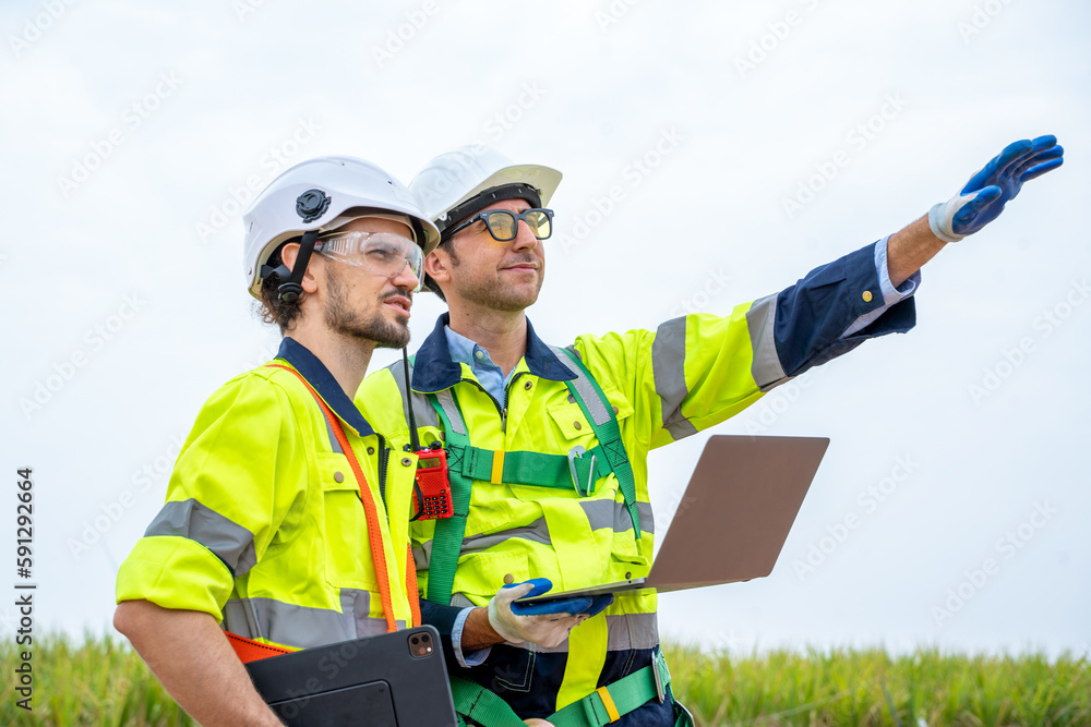 Engineer inspection and survey work in wind turbine farms rotation to generate electricity energy.