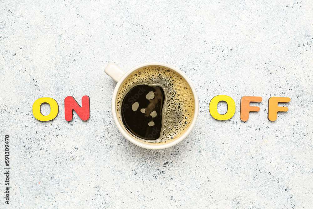 Composition with cup of coffee and colorful letters on light background