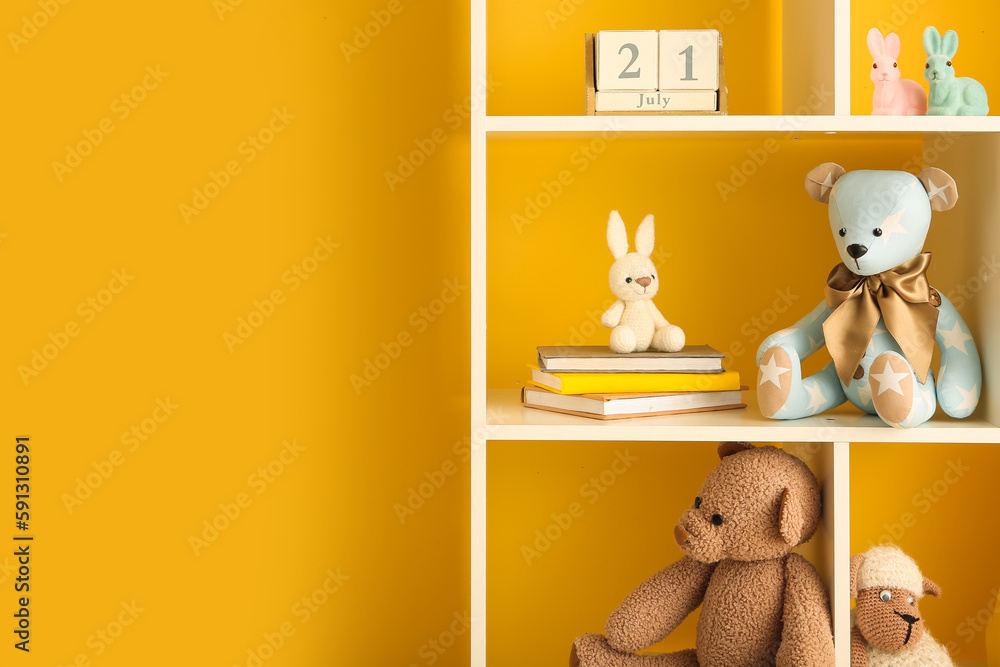 Bookshelf with baby toys near yellow wall