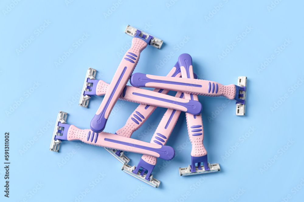 Heap of safety razors on color background