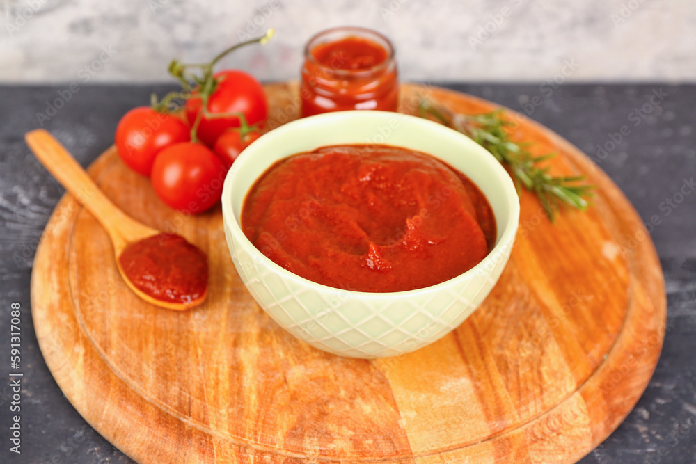 Bowl with tasty tomato paste on table