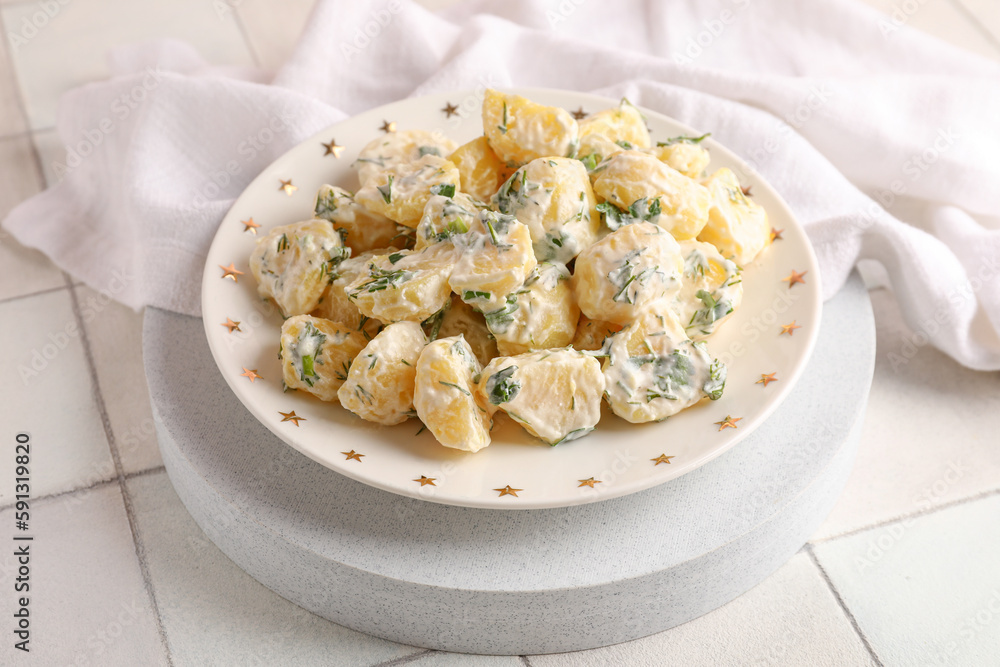 Plate of tasty Potato Salad with greens on table