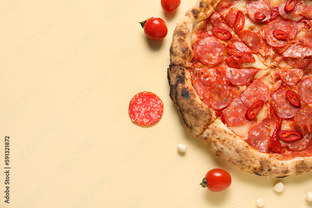 Delicious pepperoni pizza and ingredients on beige background