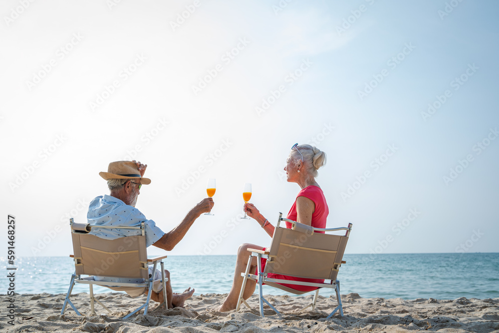 Senior couple relaxing and drink orange juice on sea beach,Summer vacation,Travel and vacation on be