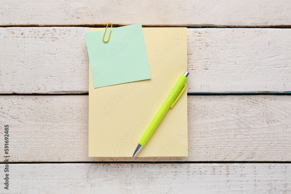 Sticky notes and pen on light wooden background