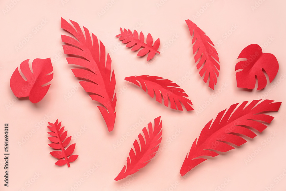 Paper tropical leaves on pink background