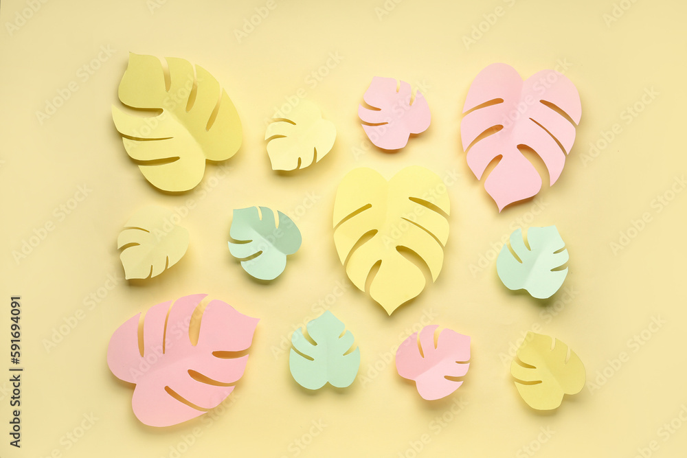 Composition with paper tropical leaves on yellow background