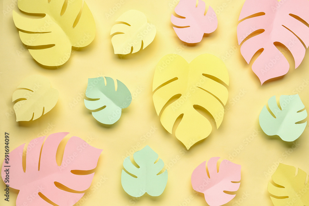 Composition with paper tropical leaves on yellow background